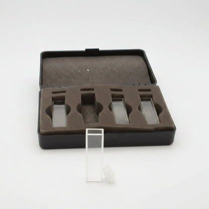 An open black presentation case with a brown foam insert holding several clear rectangular glass slides, shown on a white background with one slide standing upright in front.