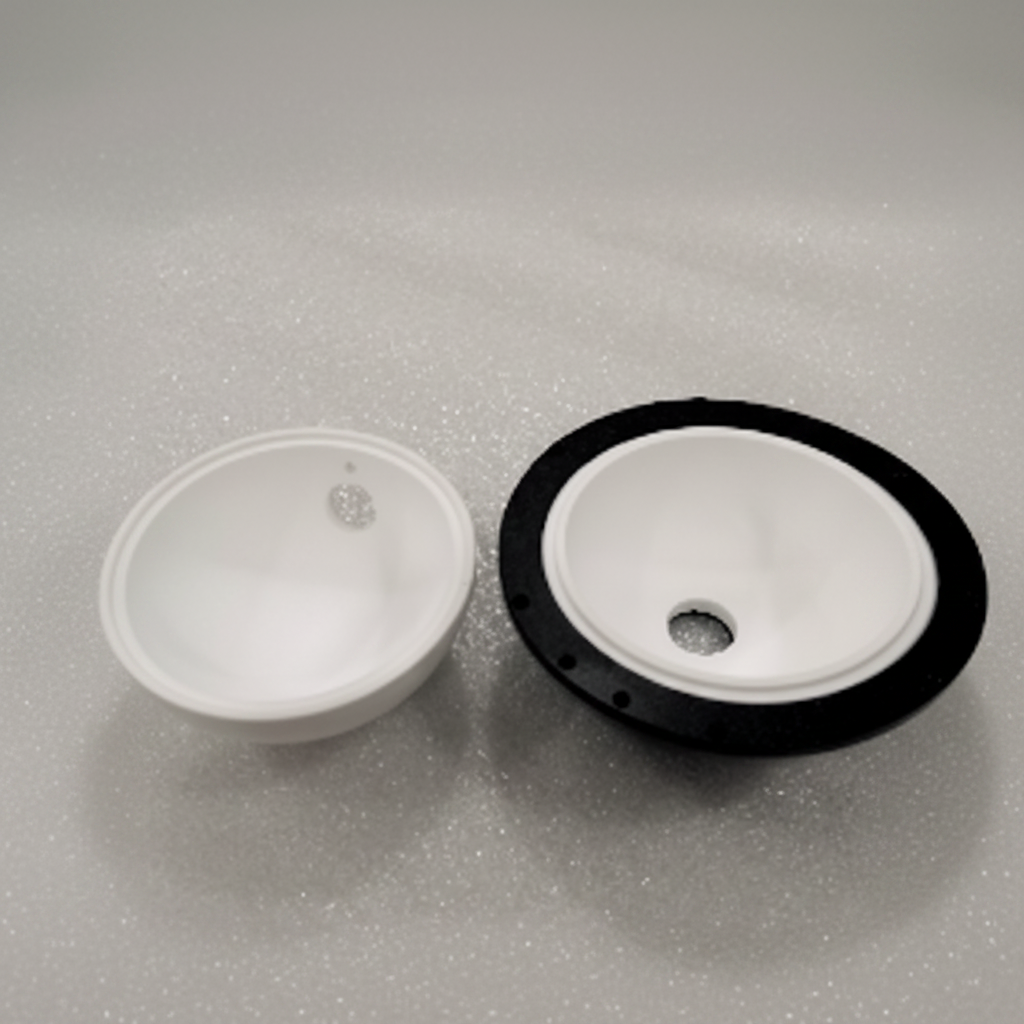Two white plastic bowl-shaped components, one plain and one with a black outer rim, shown on a light gray textured background.